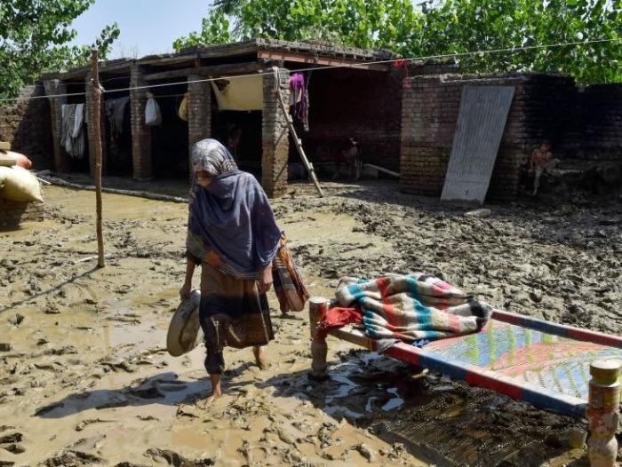 BBC Mundo: Una mujer afectada por las inundaciones camina fuera de su casa dañada en la aldea de Jindi en el distrito de Charsadda de Khyber Pakhtunkhwa el 1 de septiembre de 2022.