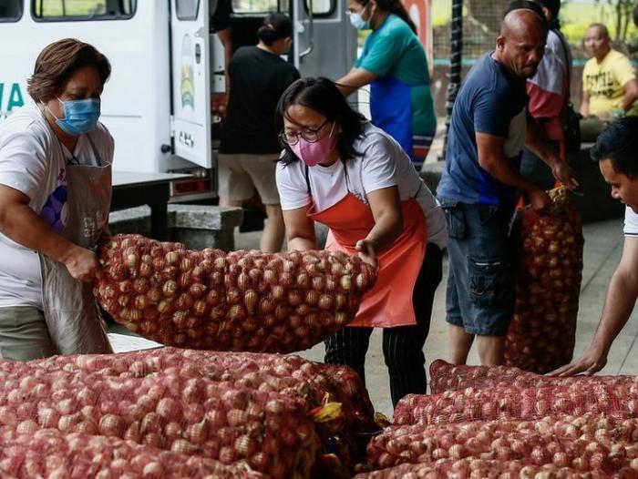 BBC Mundo: Personas cargando bolsas de cebollas en Quezon City, Manila, Filipinas el 10 de enero de 2023